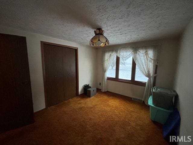 unfurnished bedroom featuring a textured ceiling and carpet floors