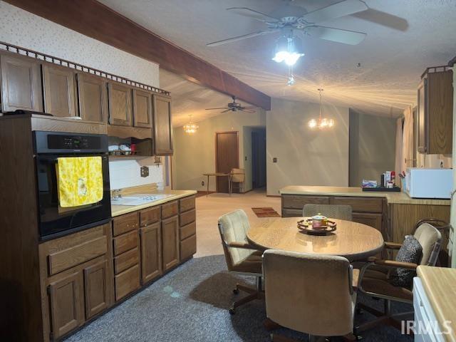 kitchen featuring a kitchen bar, light colored carpet, lofted ceiling with beams, a chandelier, and oven