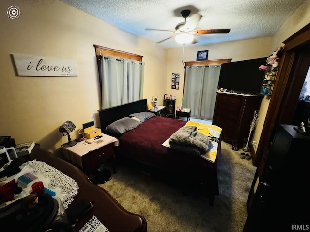 carpeted bedroom featuring ceiling fan and a textured ceiling