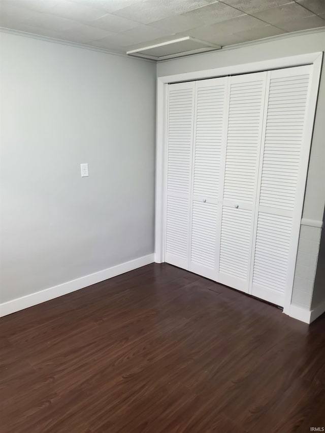 unfurnished bedroom featuring a closet and dark wood-type flooring