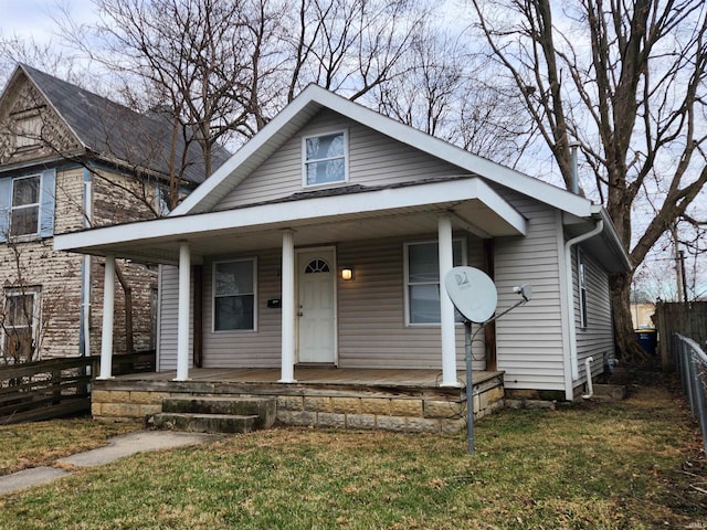 view of front of house with covered porch and a front lawn