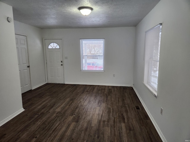 foyer featuring a textured ceiling and dark hardwood / wood-style floors