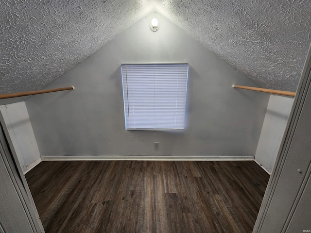 bonus room featuring lofted ceiling, dark wood-type flooring, and a textured ceiling