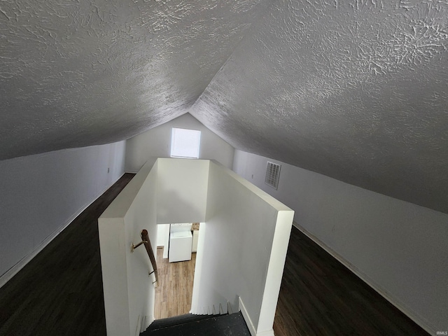 staircase with a textured ceiling and lofted ceiling