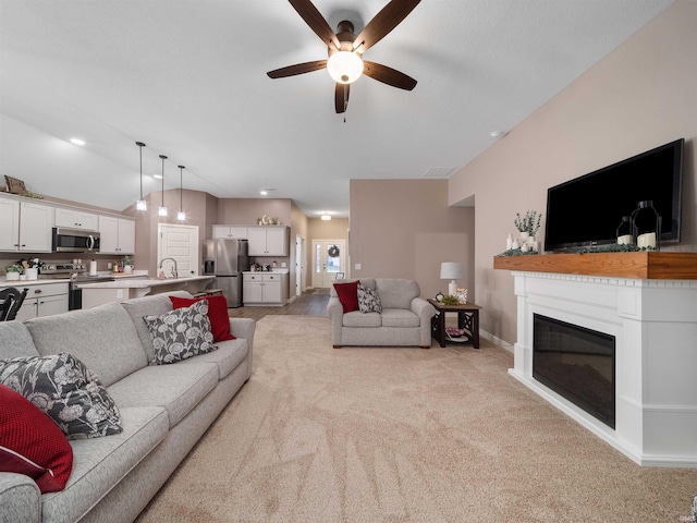 living room featuring ceiling fan, sink, and lofted ceiling