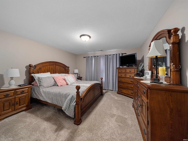 bedroom with light carpet and a textured ceiling