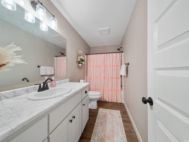 full bathroom featuring hardwood / wood-style floors, vanity, toilet, and shower / bath combo