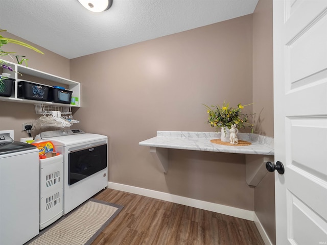 laundry area with dark hardwood / wood-style floors, independent washer and dryer, and a textured ceiling