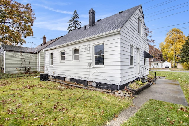 back of property featuring a lawn and central AC unit