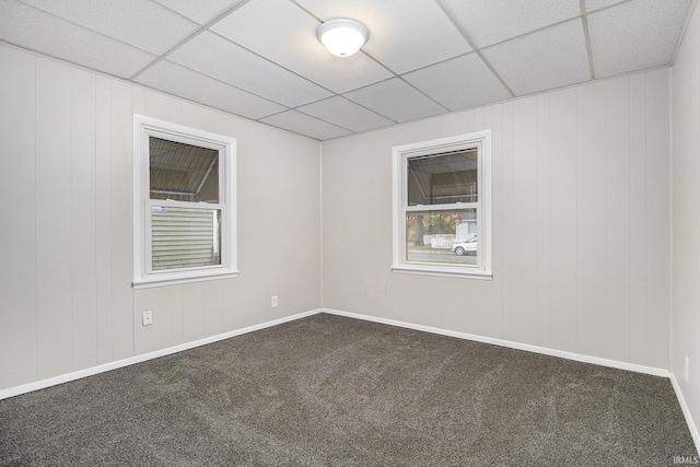 carpeted spare room featuring a paneled ceiling