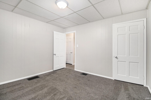 carpeted spare room featuring a paneled ceiling