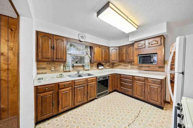 kitchen with built in microwave, sink, black dishwasher, stove, and a textured ceiling