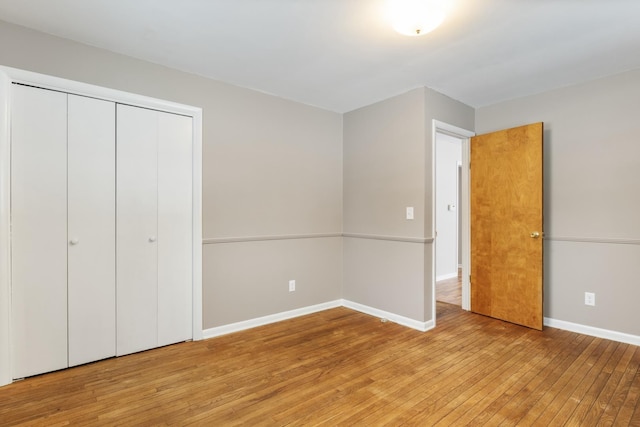 unfurnished bedroom featuring light hardwood / wood-style flooring and a closet