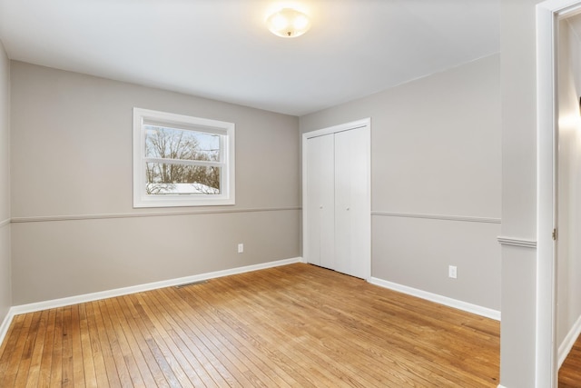 unfurnished bedroom with a closet and light wood-type flooring