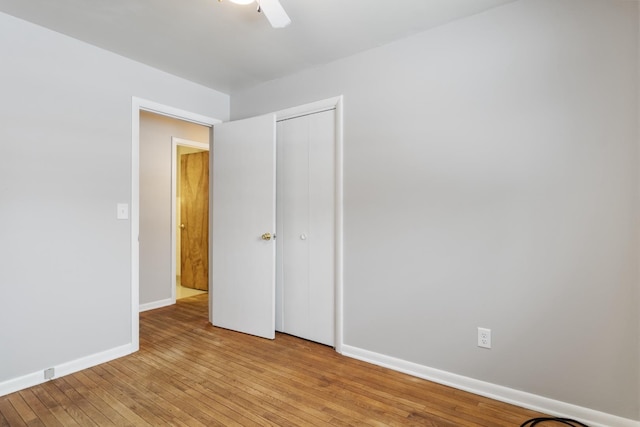 unfurnished bedroom featuring ceiling fan, light hardwood / wood-style floors, and a closet