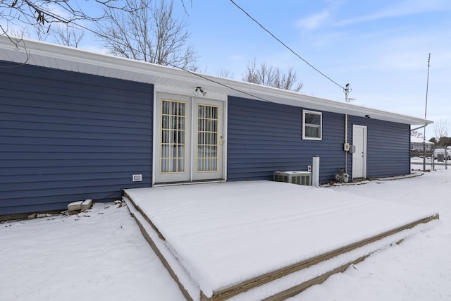 snow covered rear of property featuring cooling unit