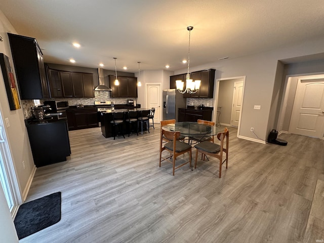 dining space with a notable chandelier and light hardwood / wood-style floors