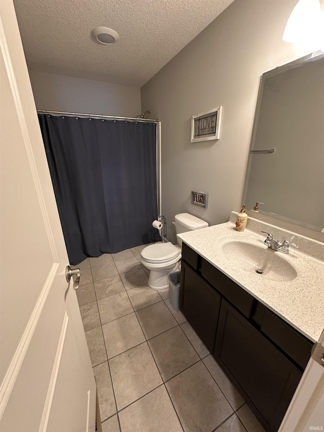 bathroom with vanity, a textured ceiling, toilet, and tile patterned flooring