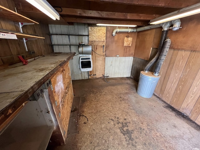 basement with heating unit, wooden walls, and a workshop area