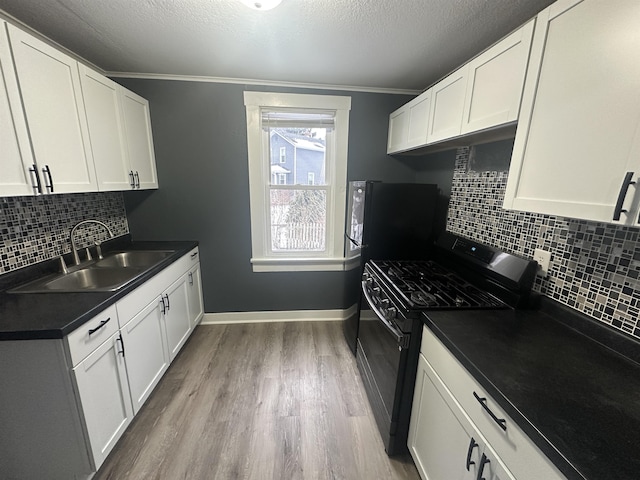 kitchen featuring white cabinets, sink, wood-type flooring, and black gas range oven