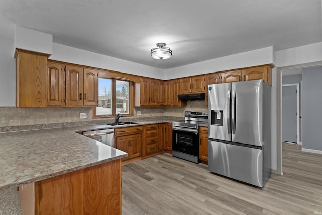 kitchen with backsplash, sink, light hardwood / wood-style floors, kitchen peninsula, and stainless steel appliances