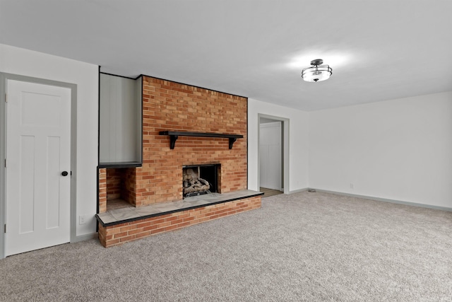 unfurnished living room featuring carpet flooring and a brick fireplace