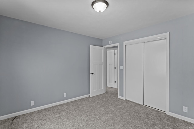 unfurnished bedroom with light colored carpet and a closet