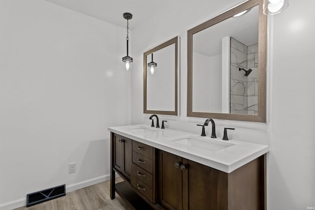 bathroom featuring vanity, wood-type flooring, and walk in shower