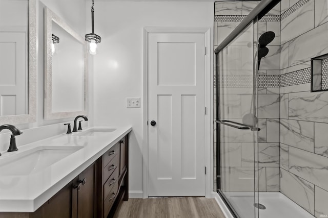 bathroom with a shower with door, vanity, and wood-type flooring