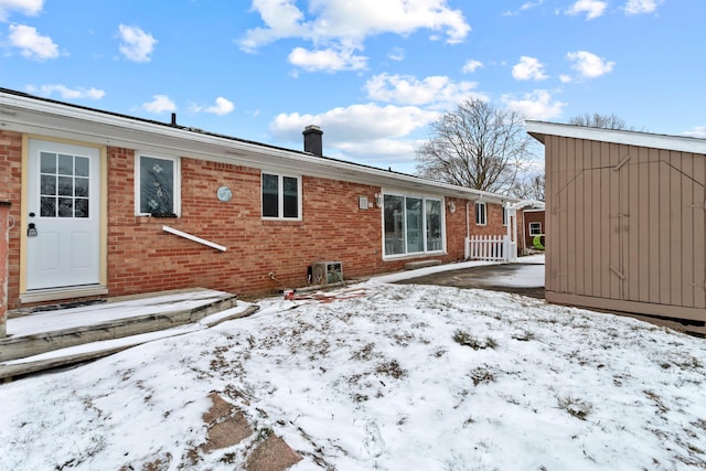 snow covered property featuring a storage shed