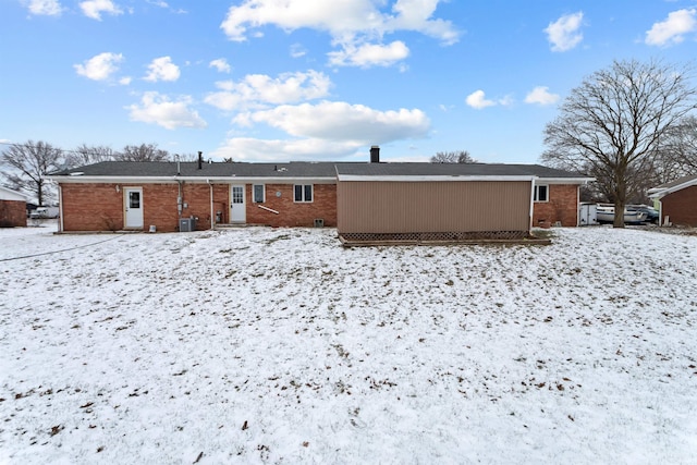 view of snow covered rear of property