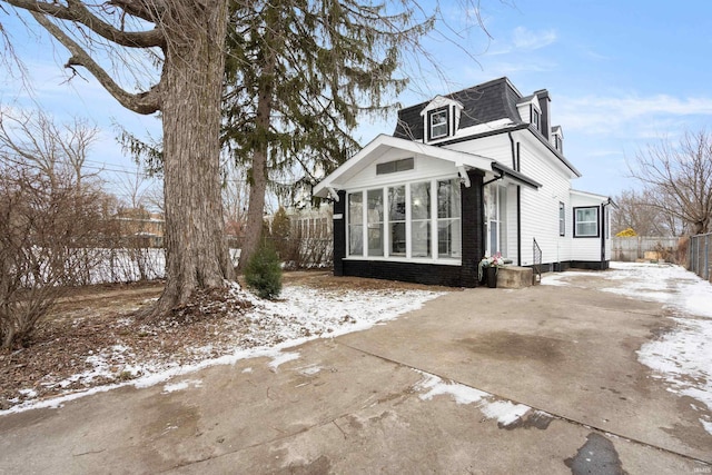 view of snow covered exterior featuring a sunroom