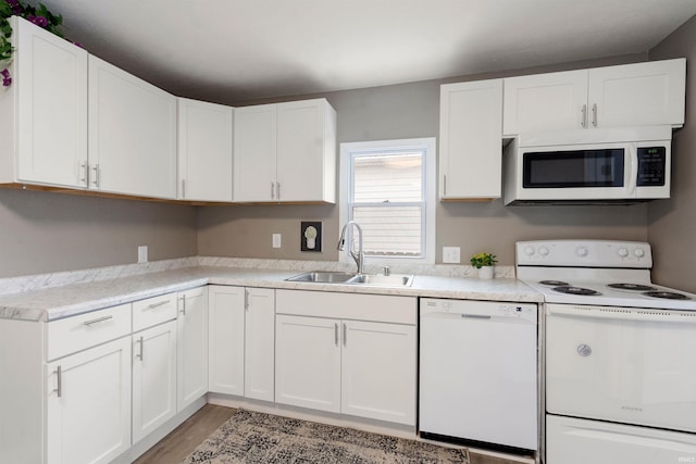 kitchen featuring white cabinetry, light wood-type flooring, white appliances, and sink