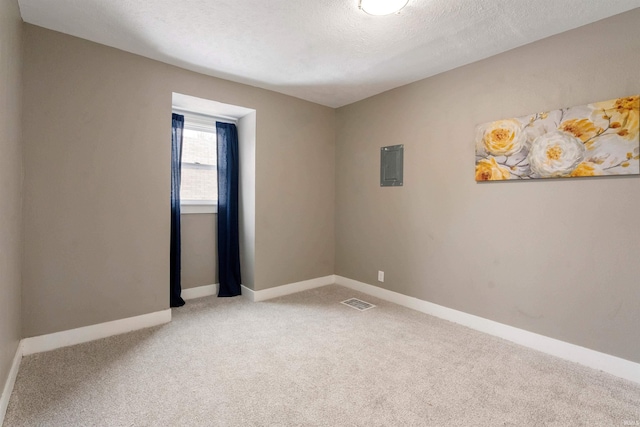 unfurnished room with electric panel, carpet floors, and a textured ceiling