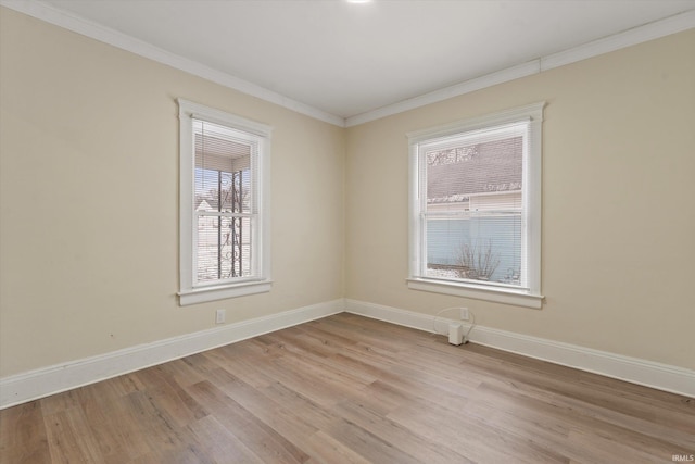 spare room with light hardwood / wood-style floors and crown molding