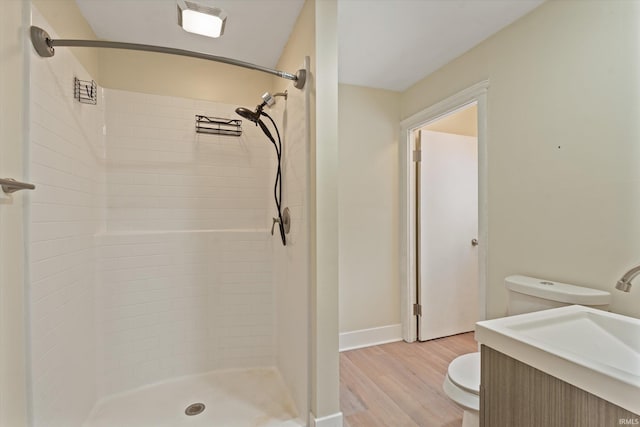 bathroom with hardwood / wood-style flooring, vanity, toilet, and a shower