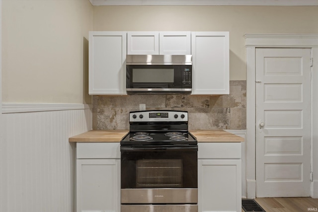 kitchen with light hardwood / wood-style flooring, white cabinets, wooden counters, and appliances with stainless steel finishes