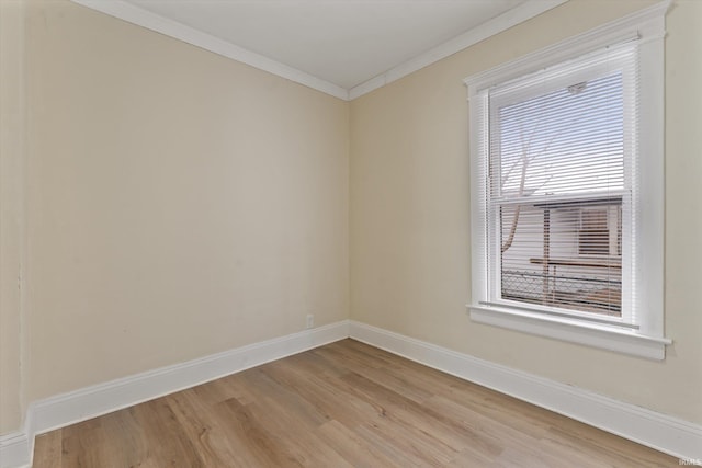 spare room featuring ornamental molding and light hardwood / wood-style flooring