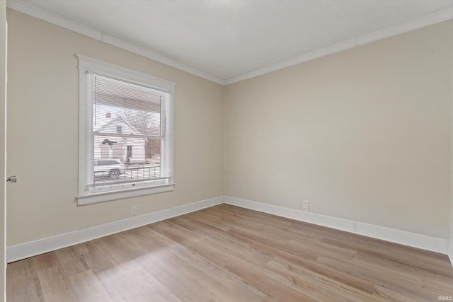 empty room with a healthy amount of sunlight, ornamental molding, and light hardwood / wood-style flooring