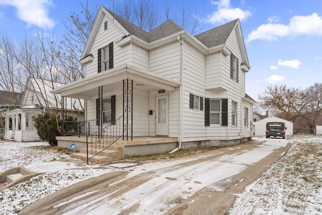 view of front of property with a porch, a garage, and an outdoor structure