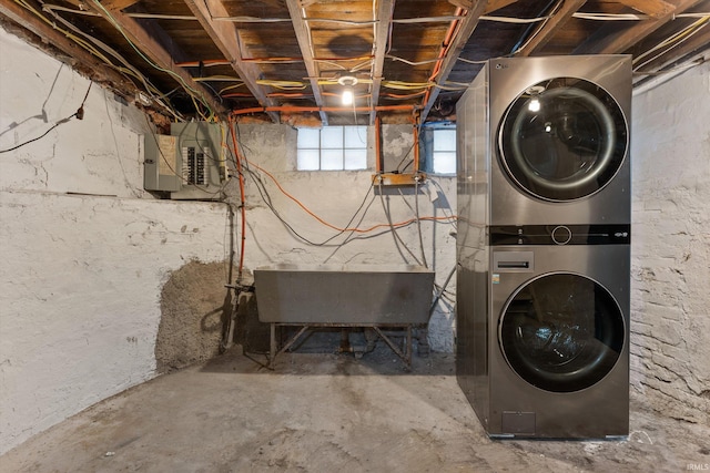 clothes washing area with electric panel, sink, and stacked washer and clothes dryer