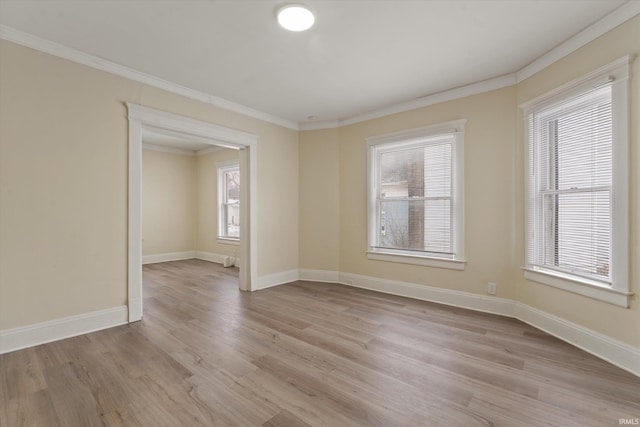 empty room with crown molding, light hardwood / wood-style flooring, and plenty of natural light