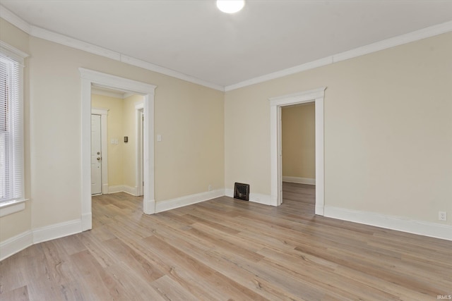 empty room with crown molding and light hardwood / wood-style flooring