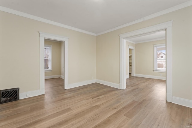 empty room featuring light hardwood / wood-style flooring and crown molding