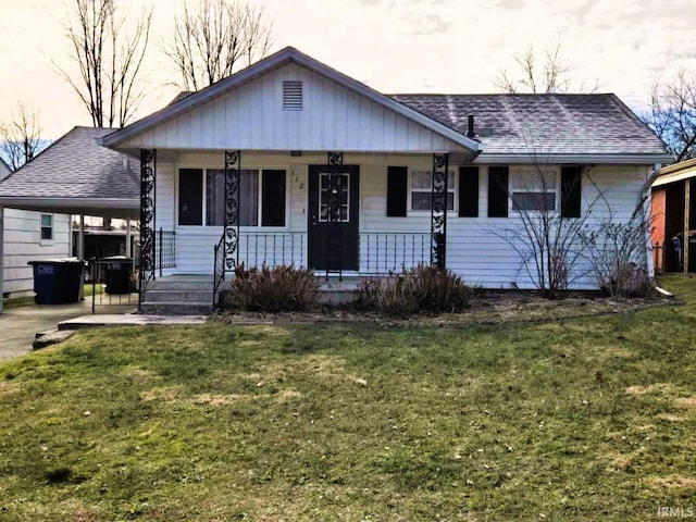 view of front facade with a carport, a porch, and a front lawn