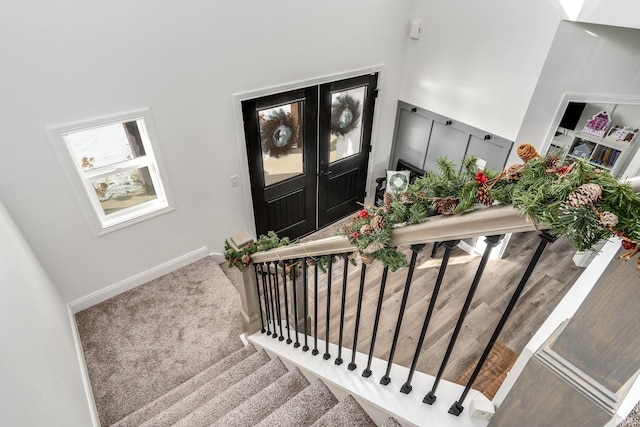 staircase with carpet, a high ceiling, and french doors