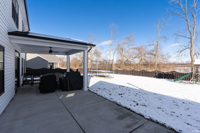 snow covered patio featuring a trampoline and ceiling fan