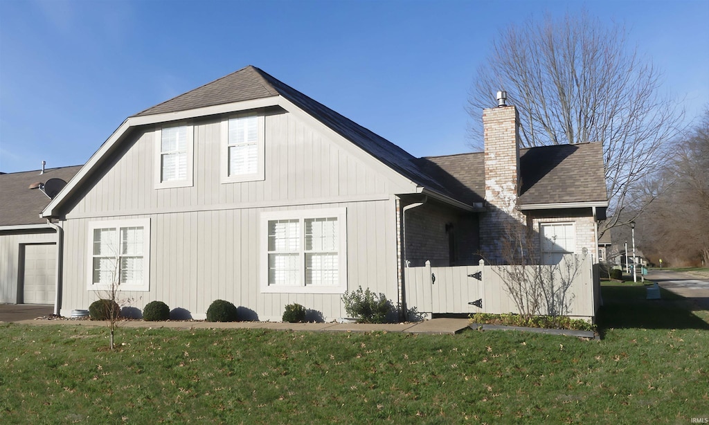 rear view of house with a garage and a yard