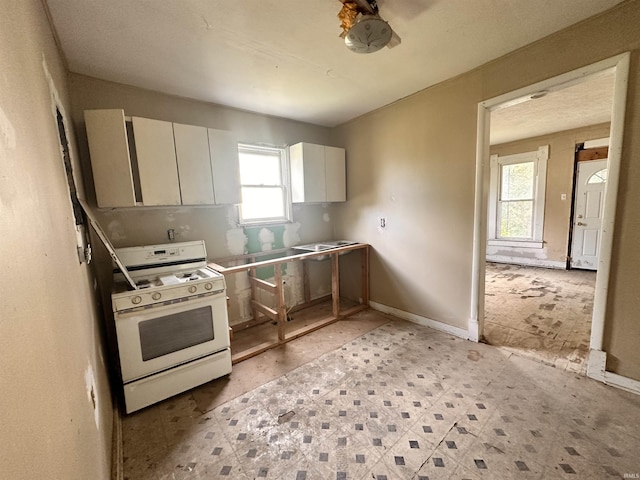 kitchen with gas range gas stove and white cabinets