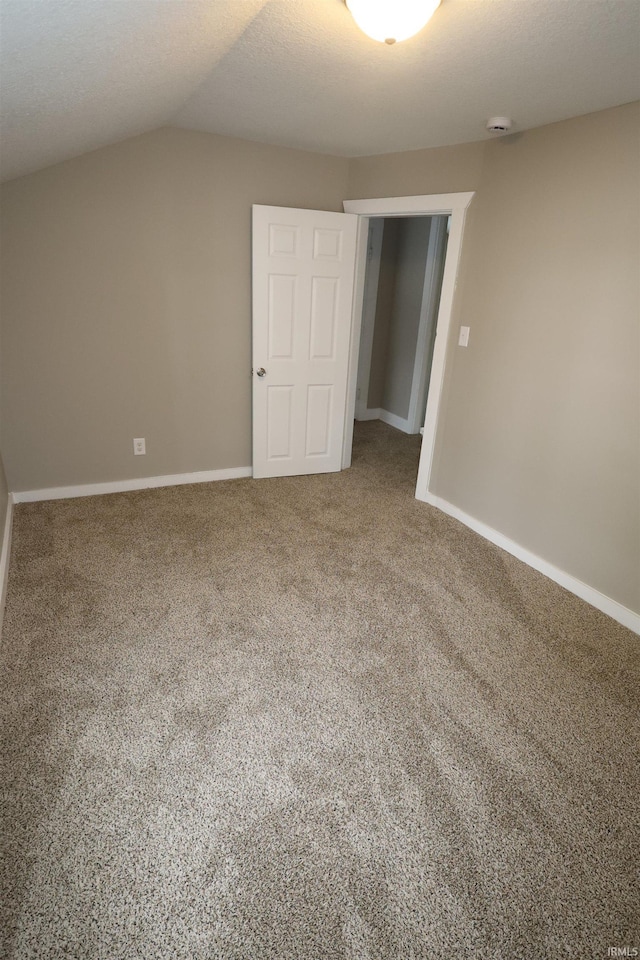 unfurnished bedroom featuring vaulted ceiling and carpet flooring